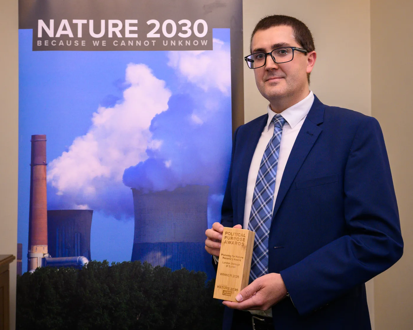 The Political Purpose Awards trophy for the Planning for Nature Recovery Award, marked London Borough of Sutton, held in front of a Nature 2030 banner.